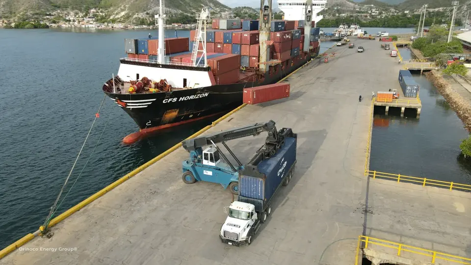 Industrial equipment on transport alongside a container vessel