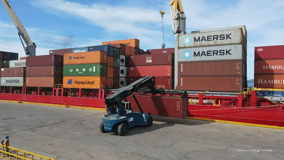 Reachstacker handling a container beside a vessel