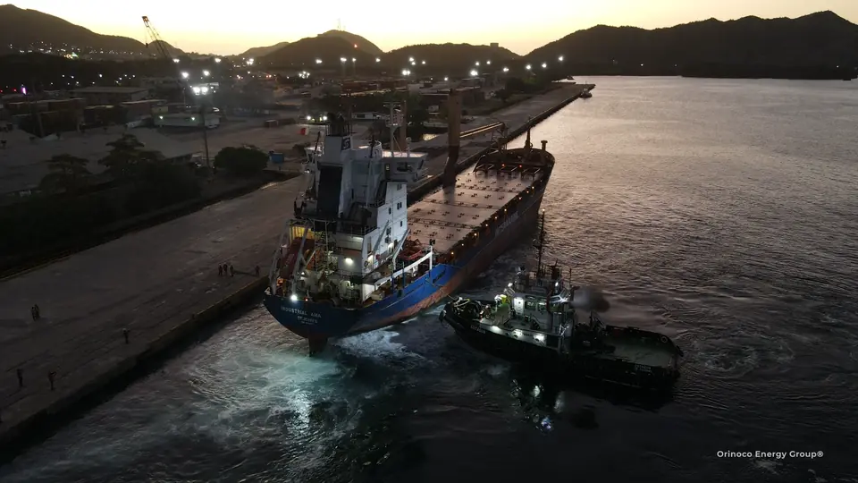 Tugboat assisting a vessel at dusk