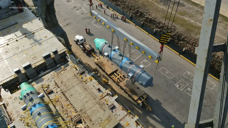 Overhead view of industrial equipment being lifted towards a trailer