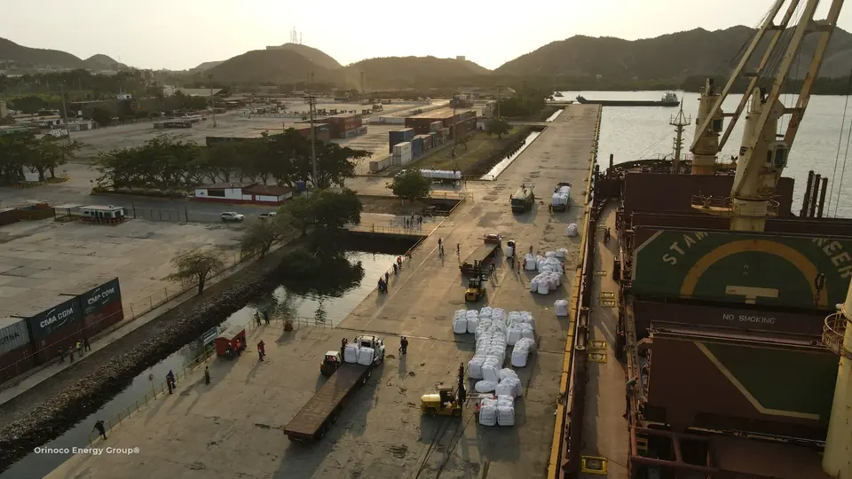 Quayside cargo and waiting transport beside a ship crane