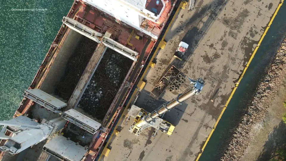Overhead view of scrap cargo handling beside a vessel